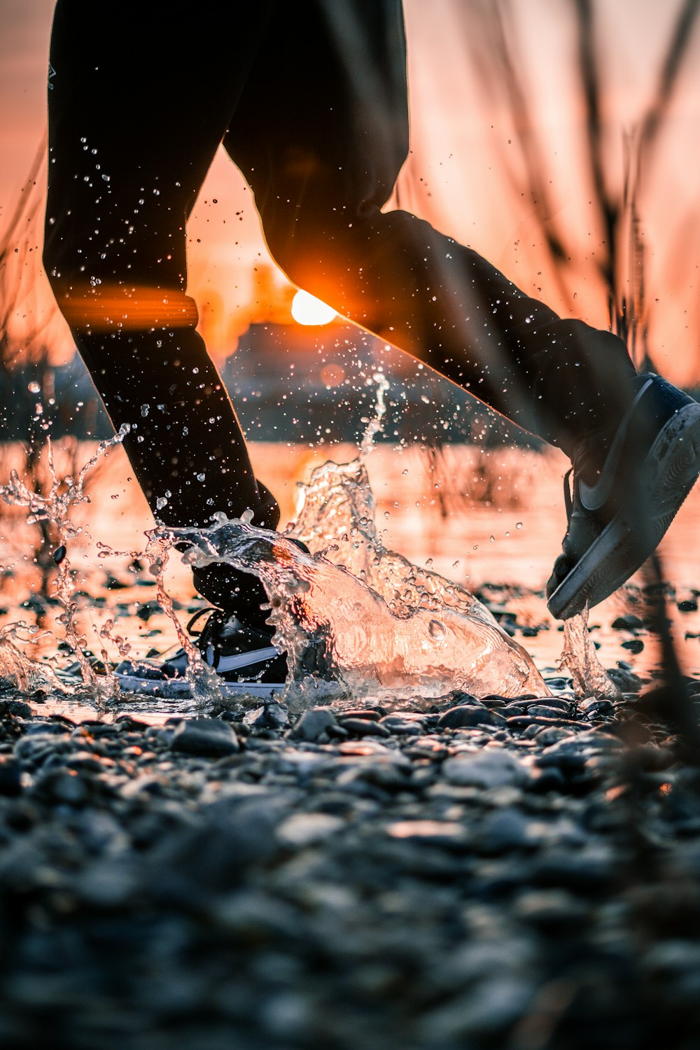 person in black and white nike athletic shoes standing on water