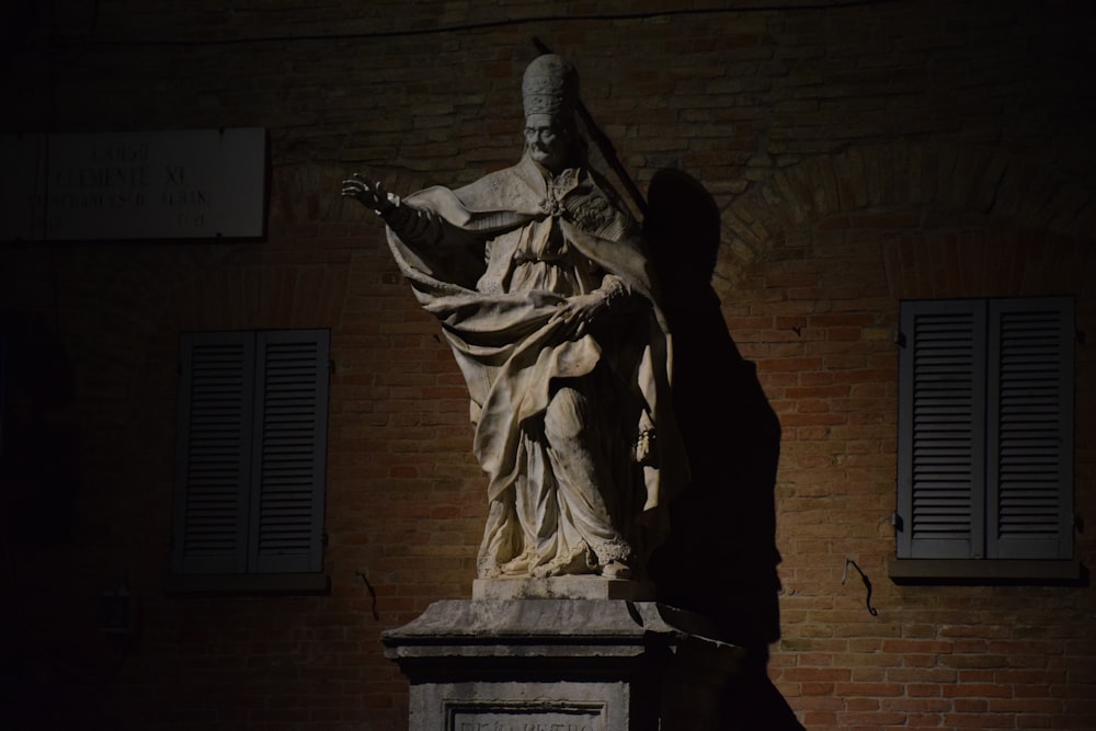 man holding a book statue