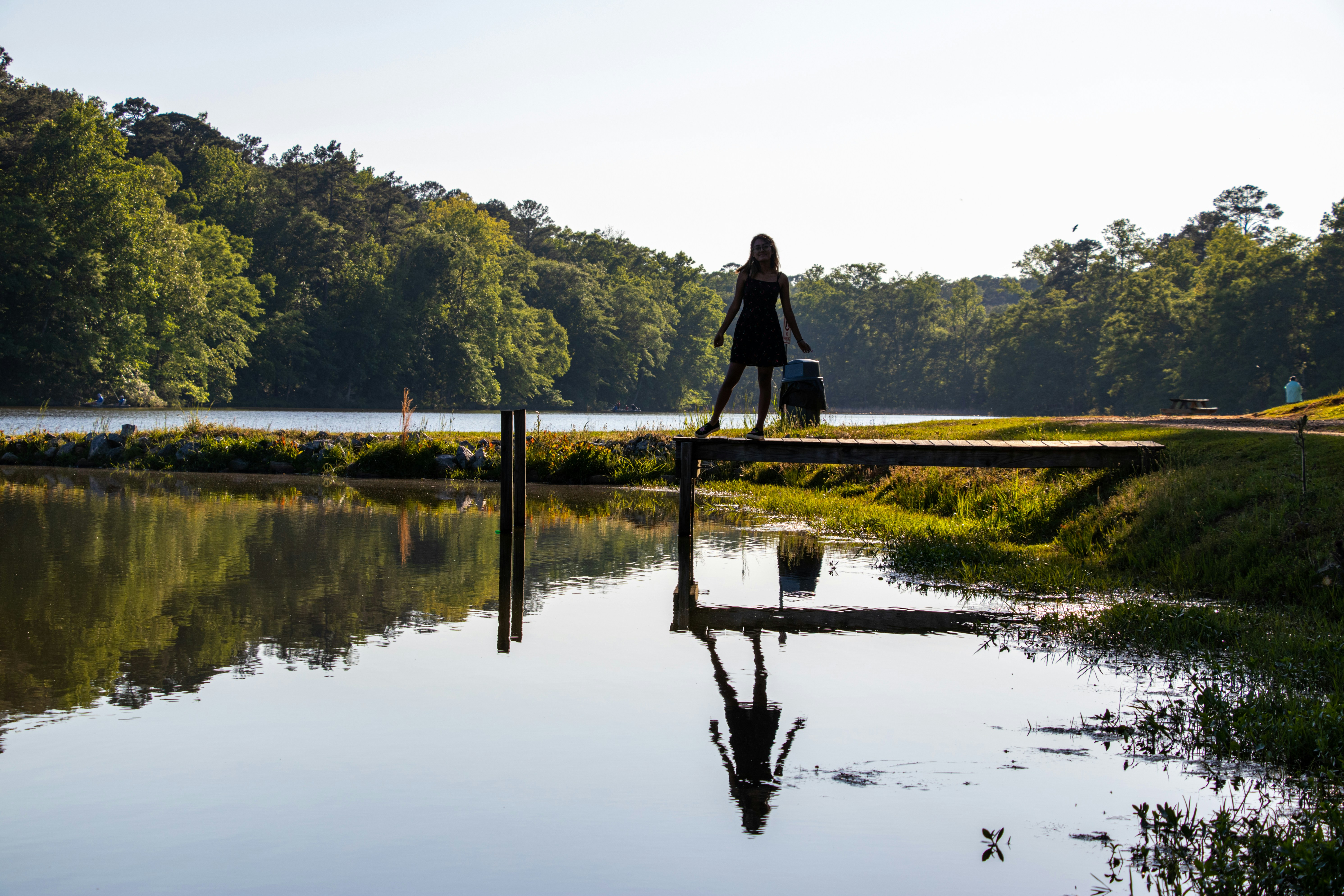 man in black jacket standing on brown wooden dock during daytime