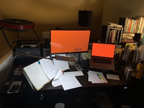 A bright workspace filled with books, coffee, and a glowing screen.