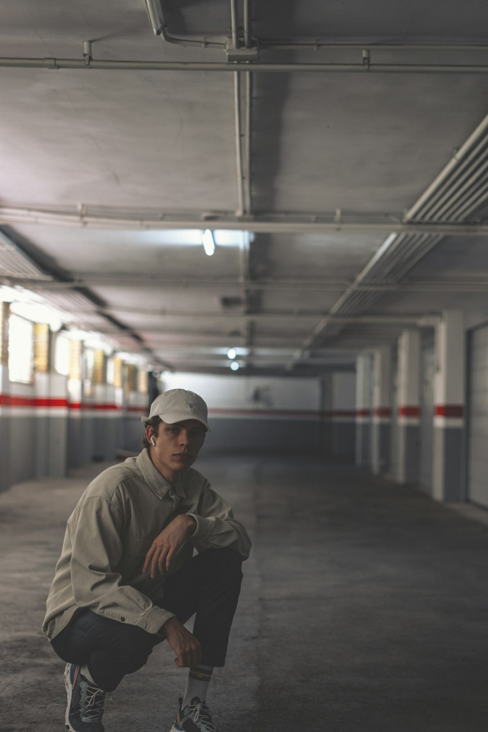 man in brown jacket and black cap sitting on train station