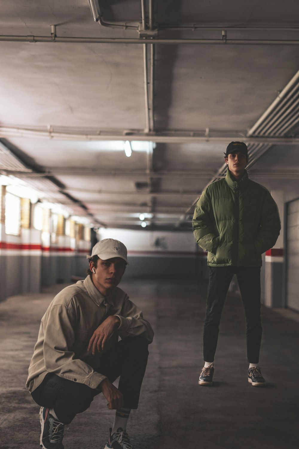 man in green jacket and black pants standing beside man in black jacket