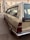 A classic Citroën car is parked on a paved street near a building with beige walls and multiple windows. The vehicle has a distinctive retro design, and the scene is calm with muted earth tones.