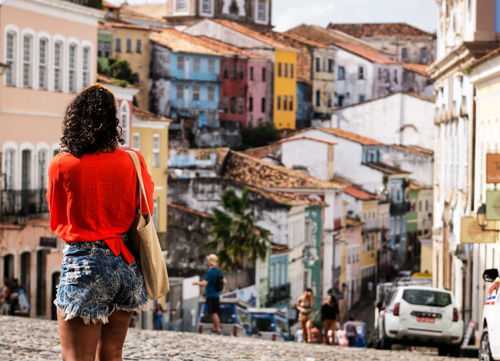 a woman standing on a cobblestone street in a city
