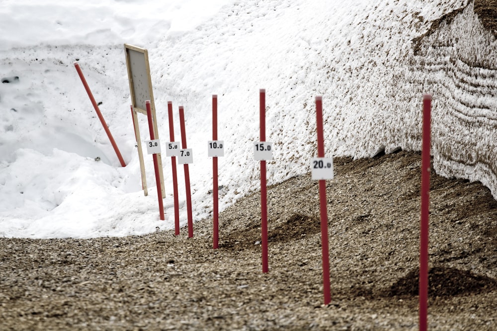 white and red wooden poles on white sand during daytime