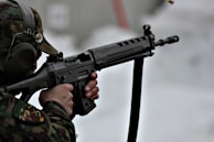 Close-up of a shooter aiming at a flying clay target with intense focus.