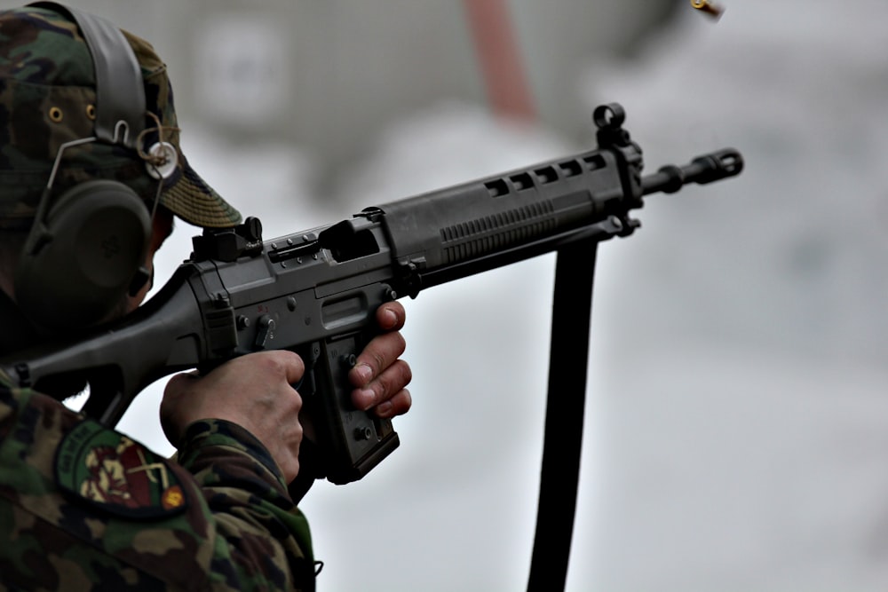 person holding black assault rifle