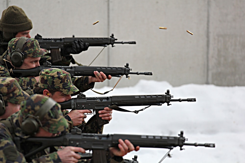 man in green and brown camouflage army suit holding rifle