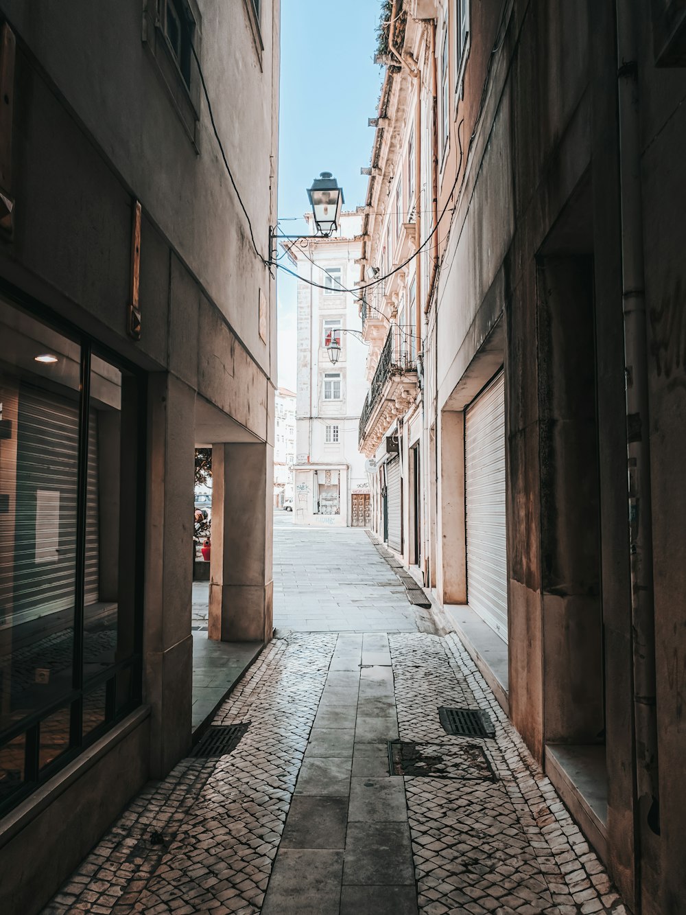 brown brick pathway between brown brick buildings during daytime