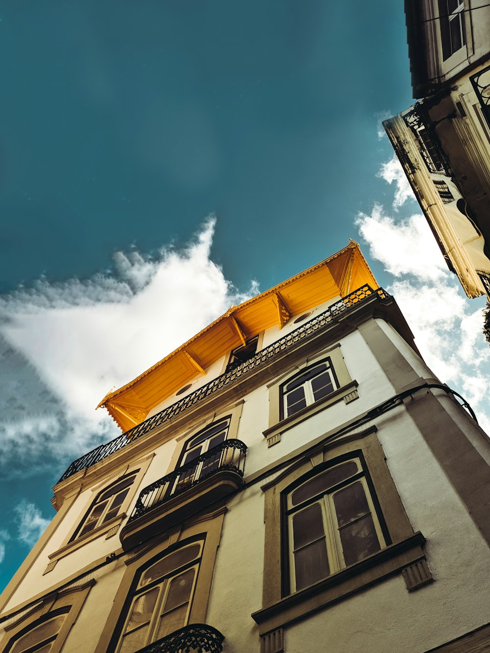 Edificio de hormigón blanco y marrón bajo el cielo azul durante el día