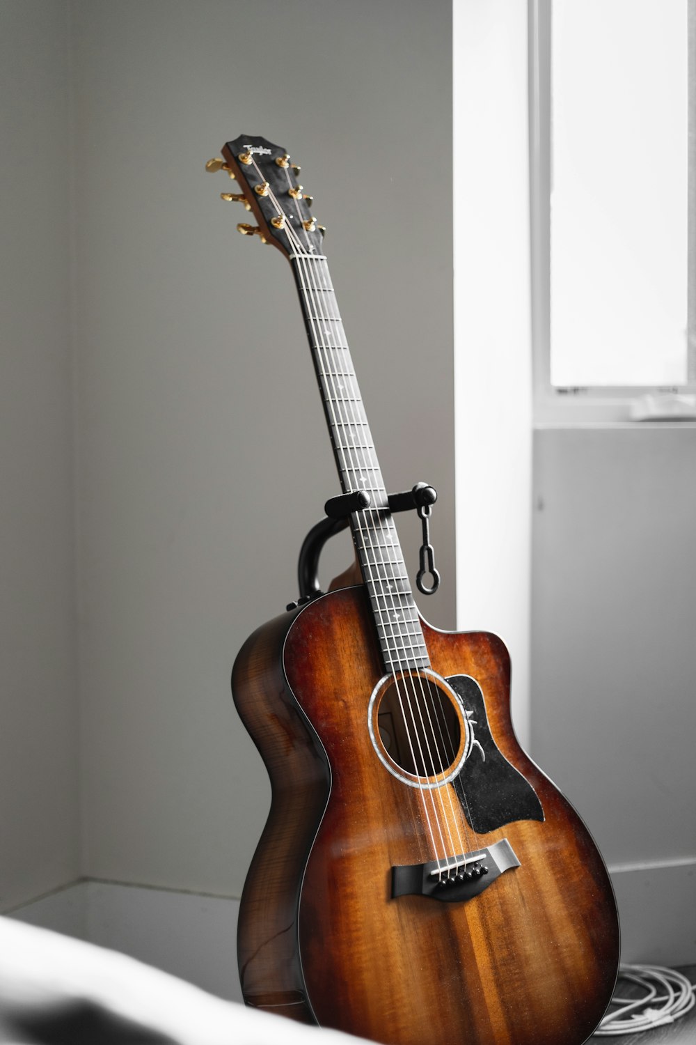 brown acoustic guitar on white wall