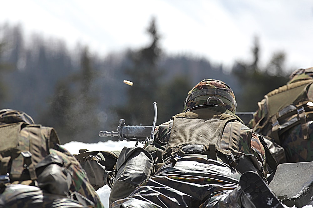 man in camouflage uniform holding rifle