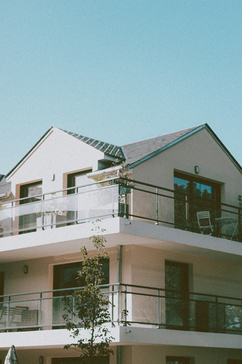 white concrete house with green tree in front