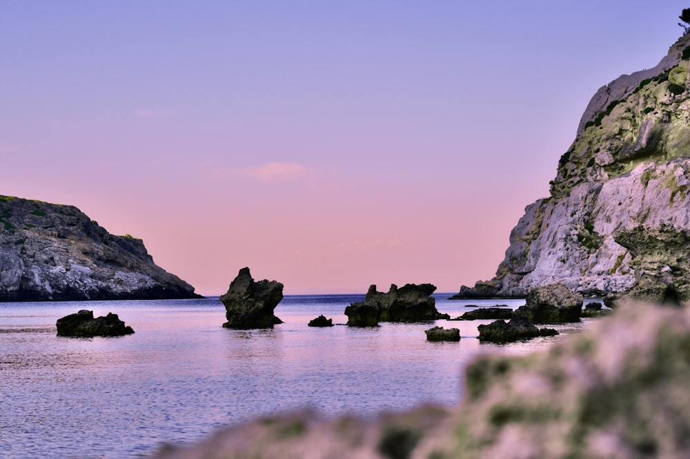 formazione rocciosa nera sullo specchio d'acqua durante il giorno