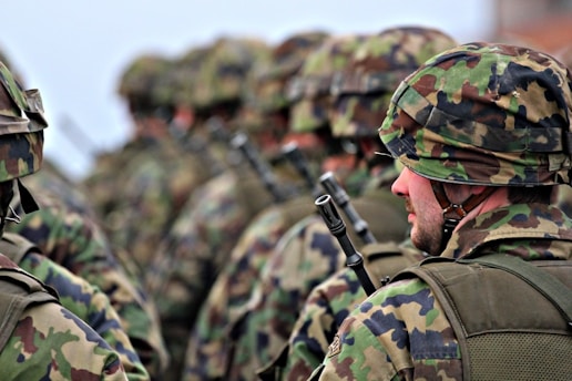 man in green and brown camouflage uniform holding black rifle