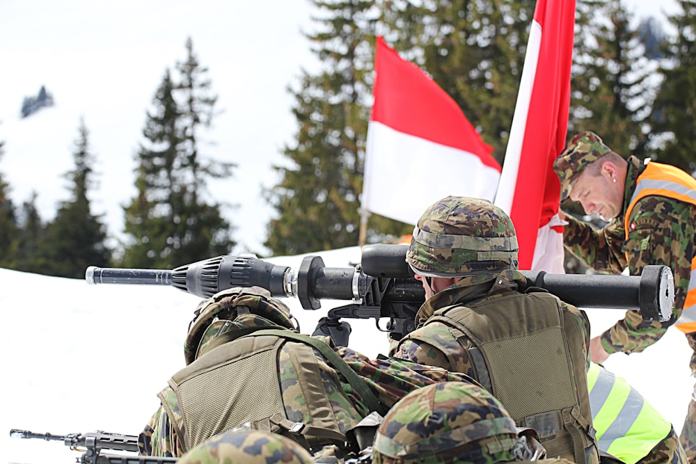 man in green and brown camouflage uniform holding black and red flag