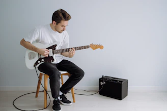 man in white crew neck t-shirt online guitar tuner  electric guitar