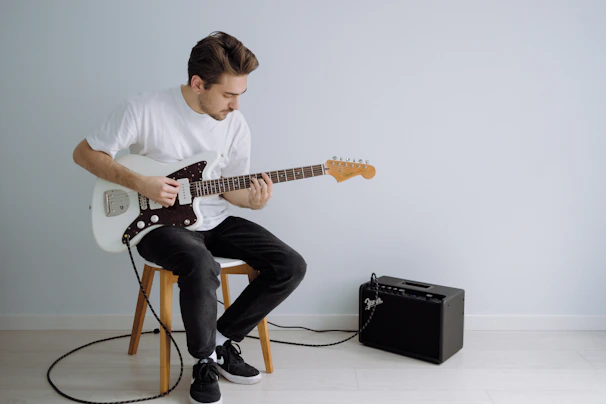man in white crew neck t-shirt online guitar tuner  electric guitar