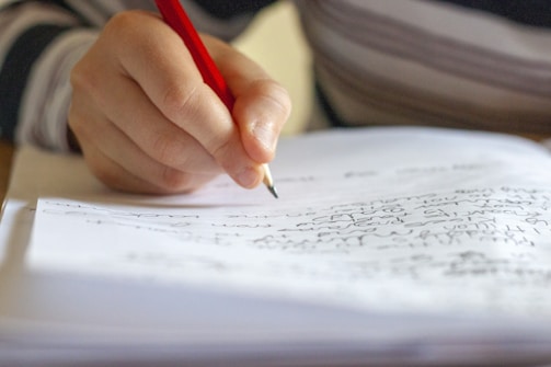 person writing on white paper