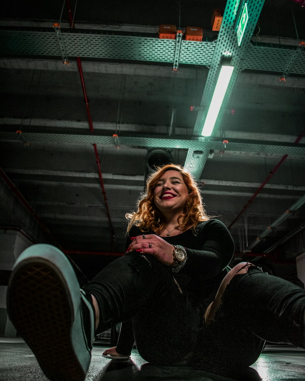 woman in black jacket sitting on black metal stairs