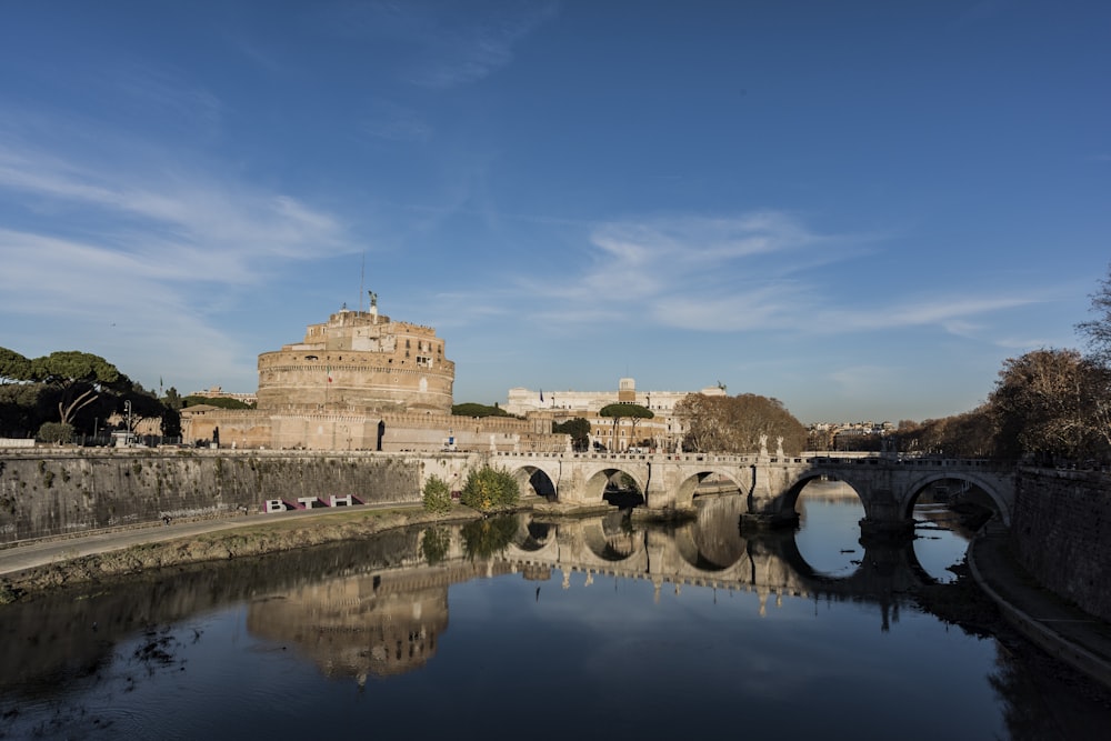 Edificio in cemento marrone vicino allo specchio d'acqua sotto il cielo blu durante il giorno