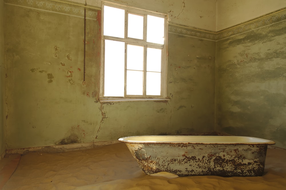 white ceramic bathtub near window