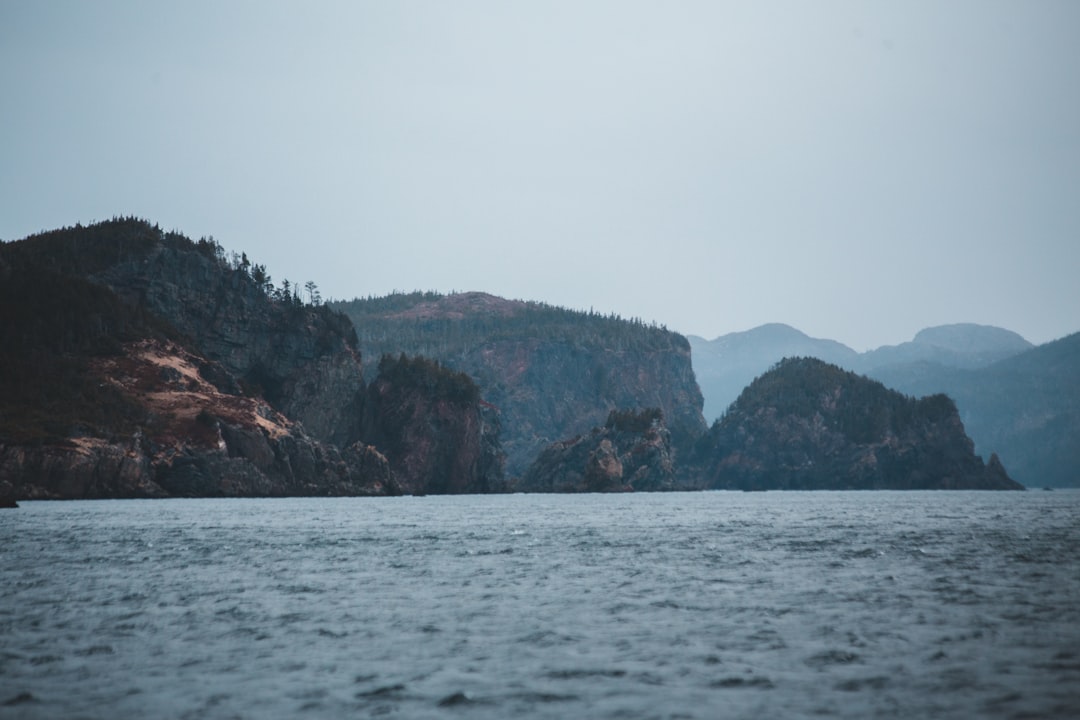 body of water near mountain during daytime