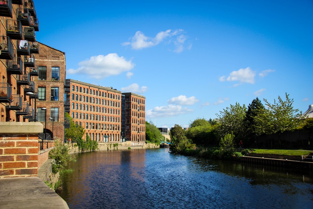 Braunes Betongebäude in der Nähe des Flusses unter blauem Himmel tagsüber