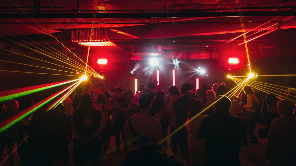 people standing on stage with lights turned on during nighttime