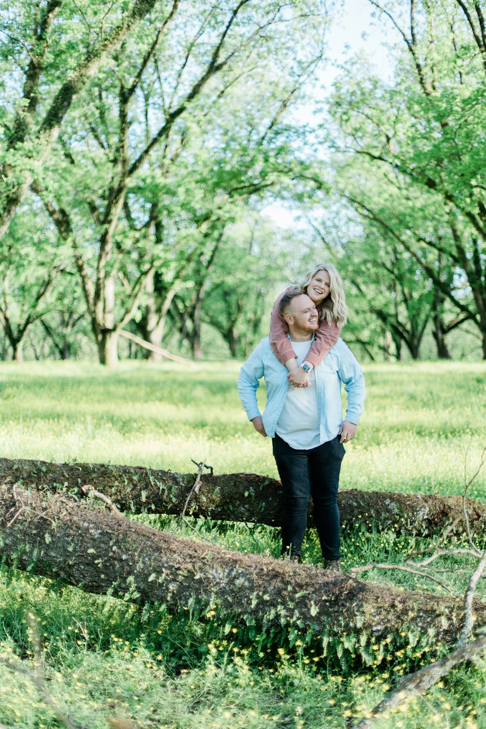 woman in blue denim jacket standing on brown tree trunk during daytime