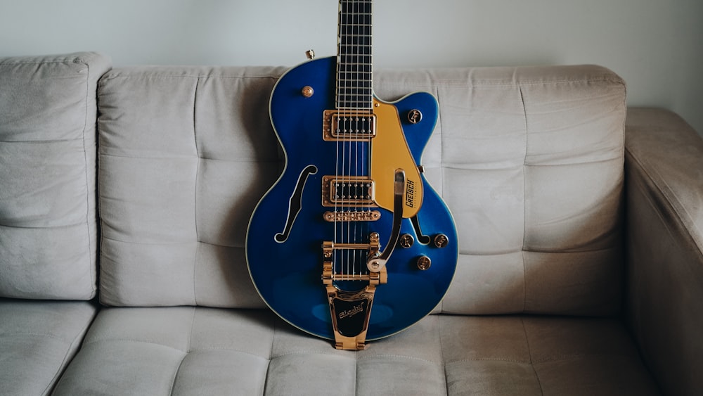 blue and brown electric guitar on white textile