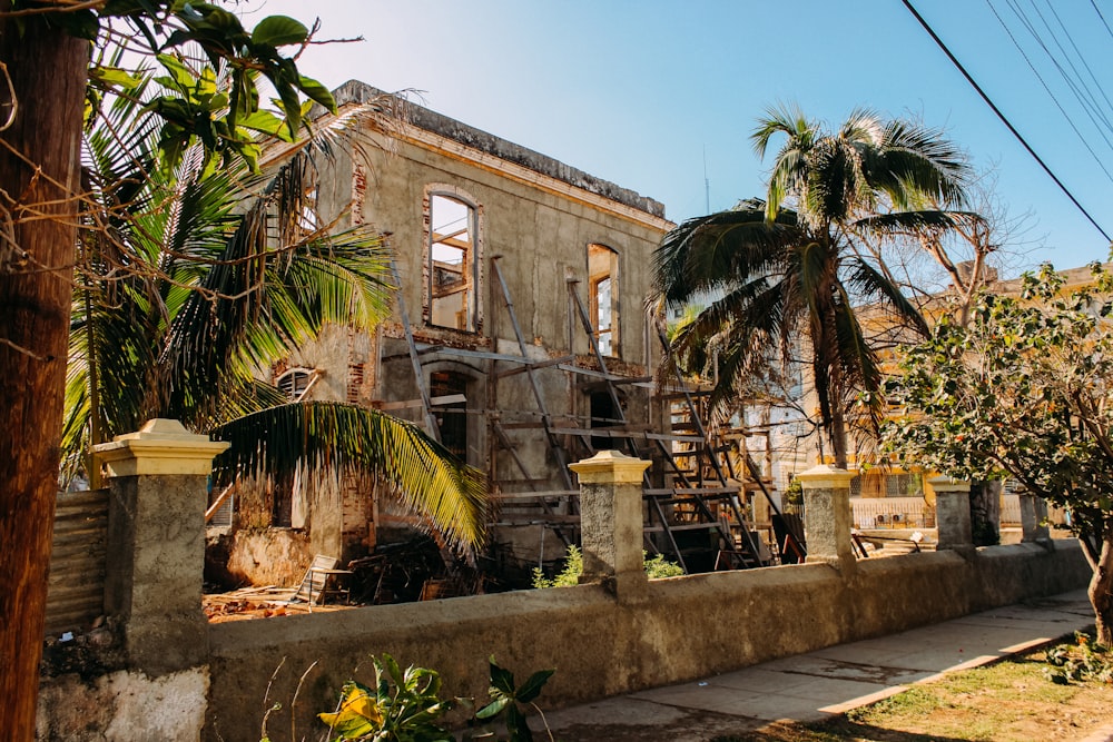 brown concrete building near palm trees during daytime