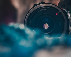 Close-up of a professional camera lens with soft background bokeh.