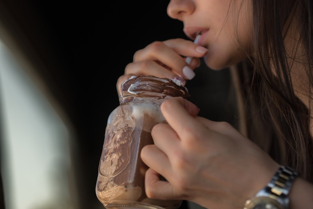 woman holding clear glass jar