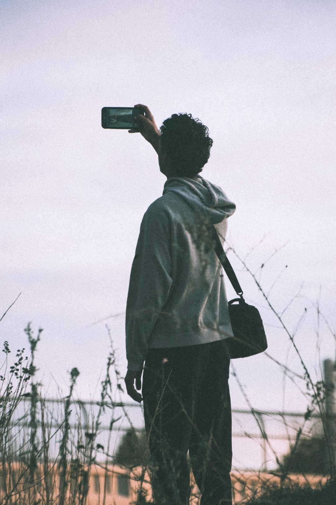 man in gray hoodie holding camera