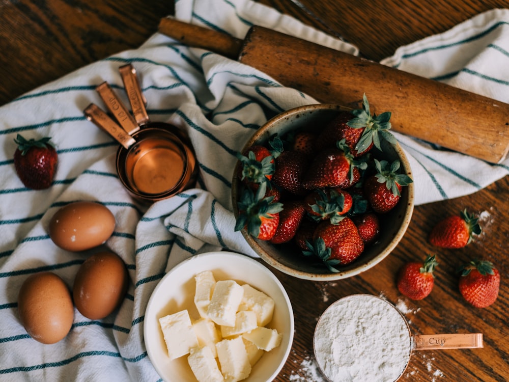 strawberries and sliced bananas on white ceramic bowl