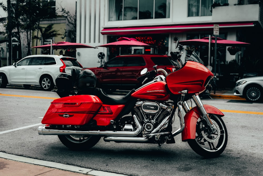 red and black cruiser motorcycle parked on gray asphalt road during daytime