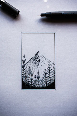 A mechanical engineer sketching a custom product design with mountain peaks in the background.