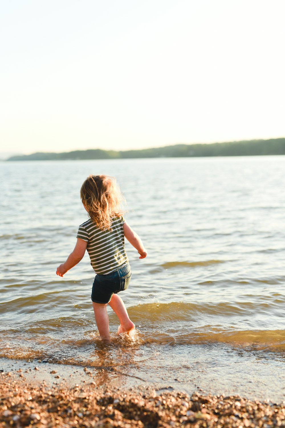girl in black and white stripe shirt running on water during daytime