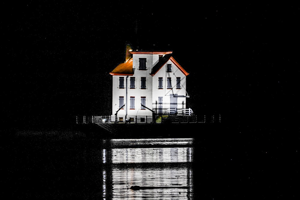 夜間の水域の白と茶色の家