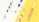 Four toothbrushes with different colorful designs are laid out against a split background of white and yellow. The toothbrushes feature combinations of blue, green, red, and pink colors.