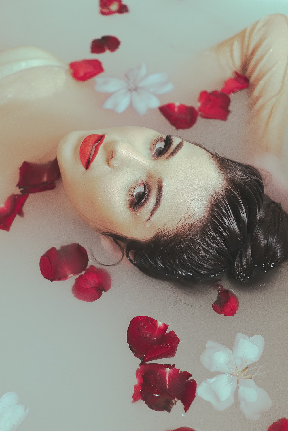 woman in bathtub with red petals