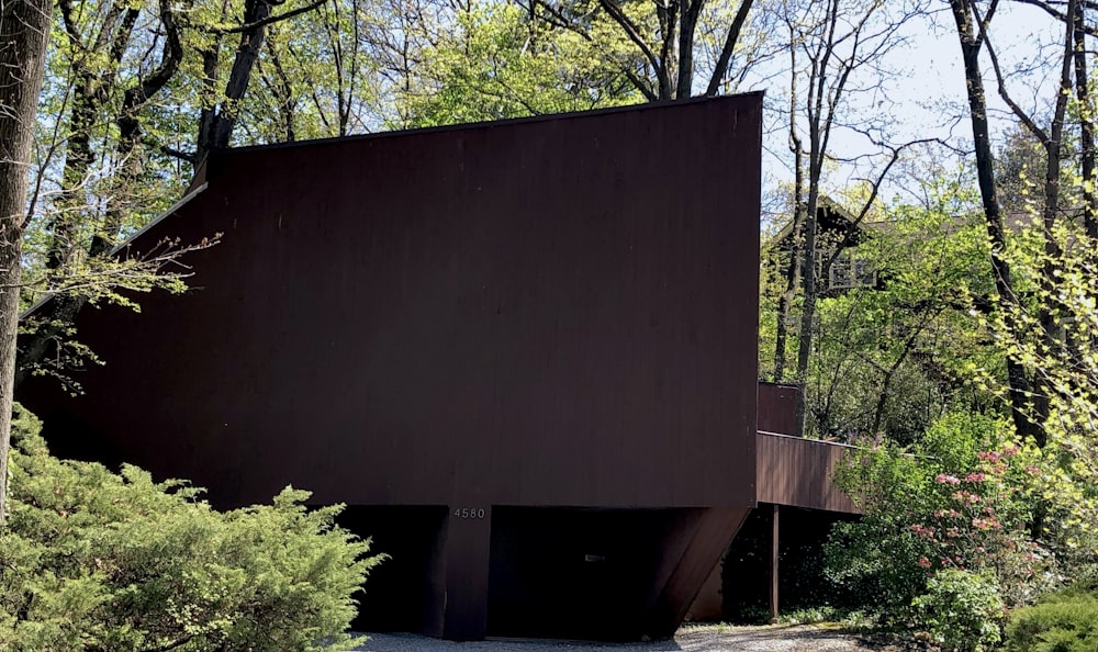 brown wooden wall near green trees during daytime