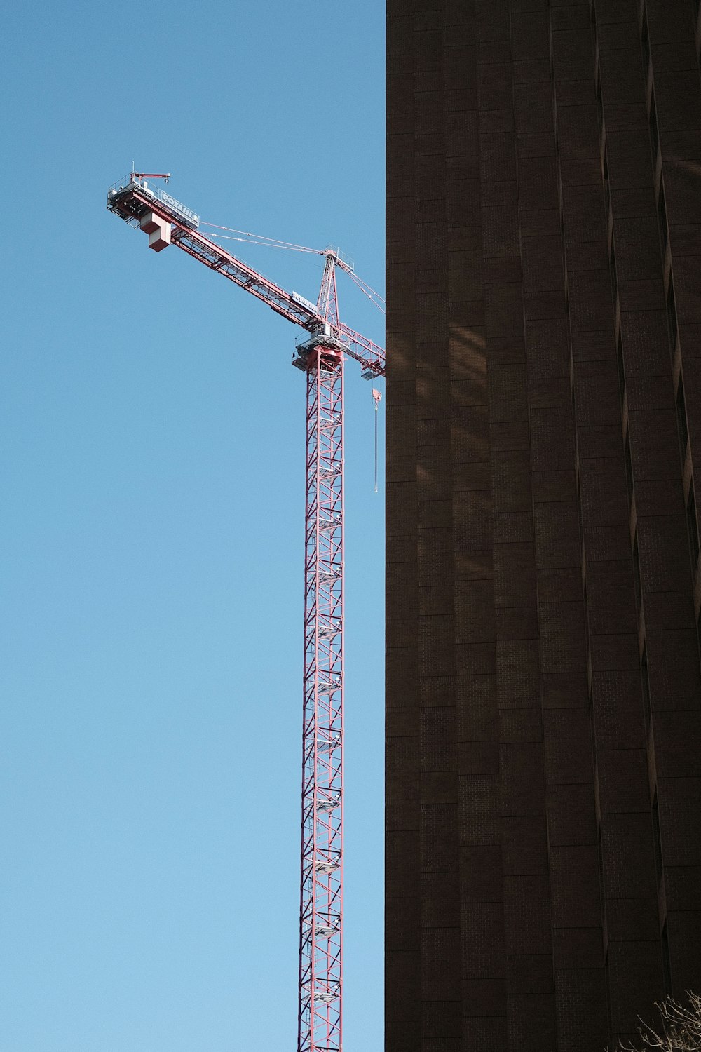 red metal crane under blue sky during daytime