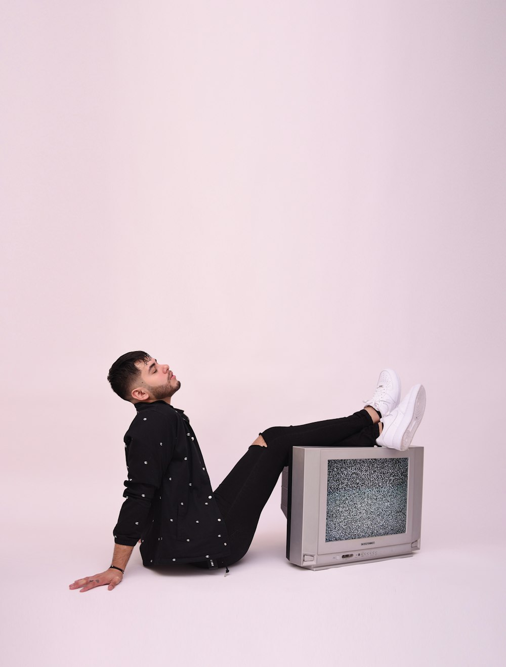 boy in black and white polka dot long sleeve shirt sitting on white chair