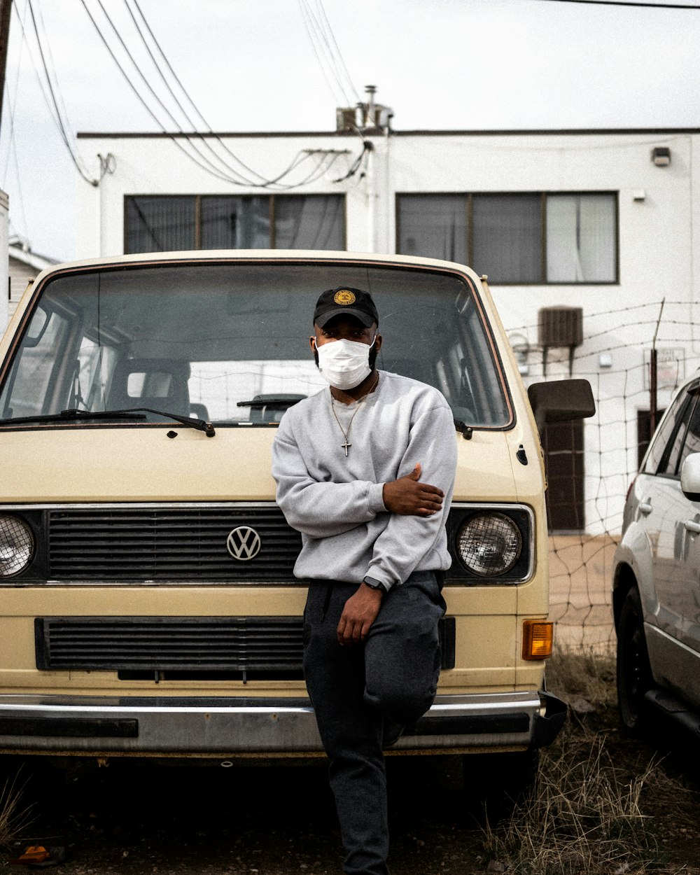 man in white dress shirt and black pants standing beside yellow car