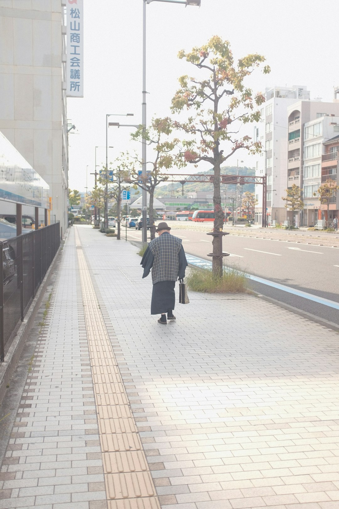 woman in black coat walking on sidewalk during daytime