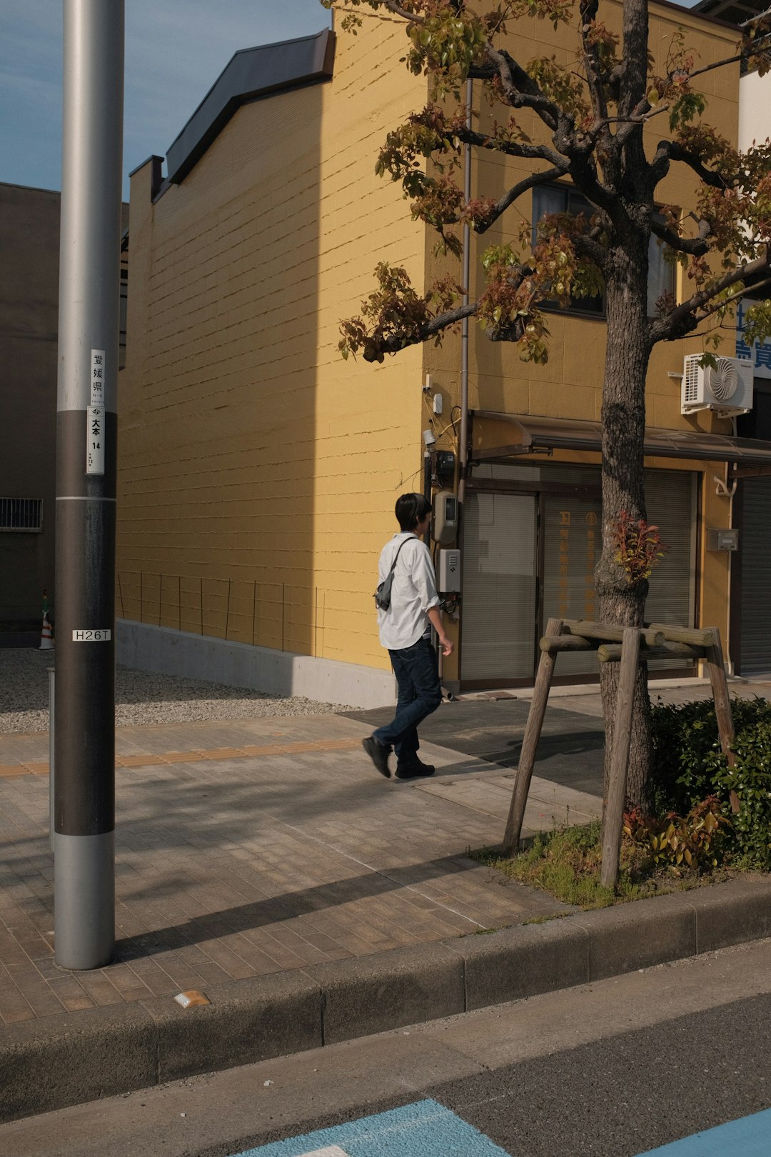 man in white dress shirt and black pants walking on sidewalk during daytime