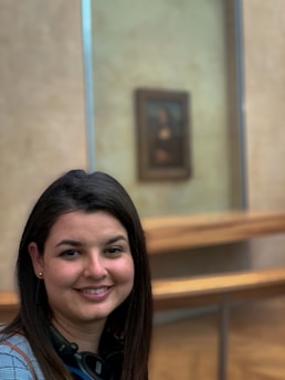 Portrait of a confident woman leader smiling warmly against a backdrop of diverse global landmarks.