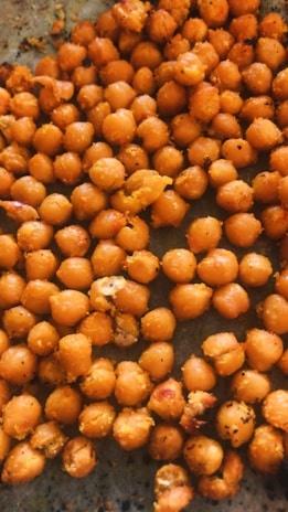 Golden roasted chickpeas sprinkled with paprika and fresh herbs on a rustic wooden table.